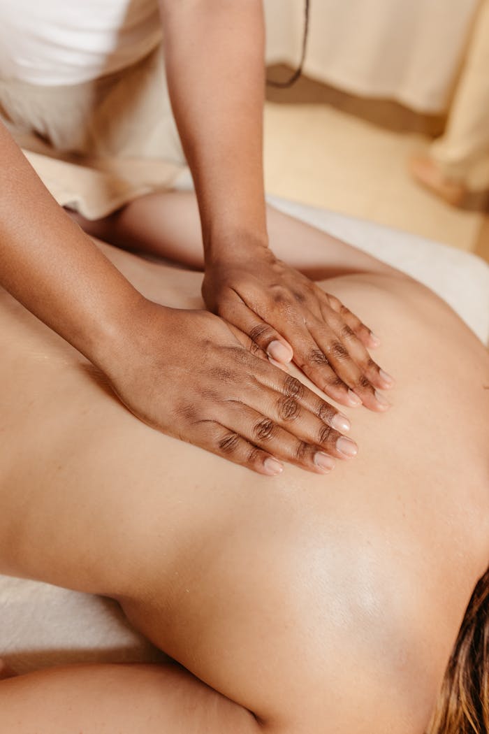 services-03 Close-up of a relaxing spa massage with a therapist massaging a woman's back.