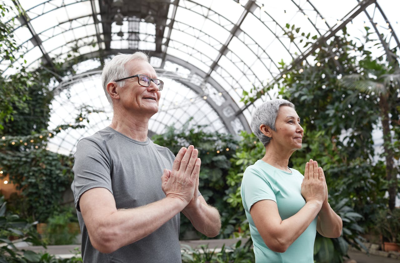 our-story Senior couple enjoying a yoga session indoors, promoting harmony and healthy lifestyle.