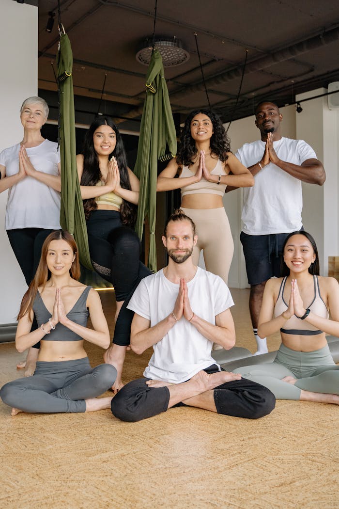 gallery-05 A multicultural group practicing yoga poses in an indoor studio setting, embracing health and mindfulness.