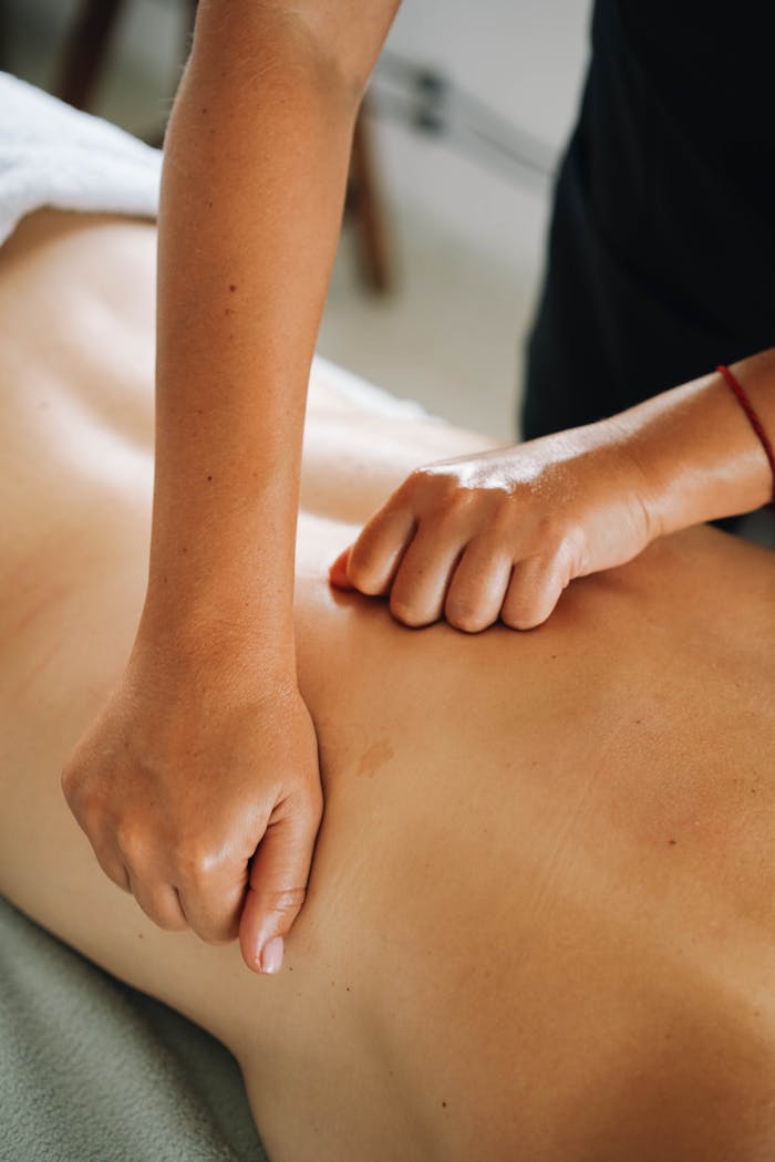 services-02 Close-up of a relaxing therapeutic massage focusing on back muscles in a tranquil spa environment.